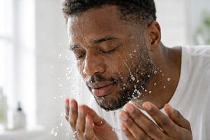 Man splashing water on face in self-, a Photo by Dvoevnore photos