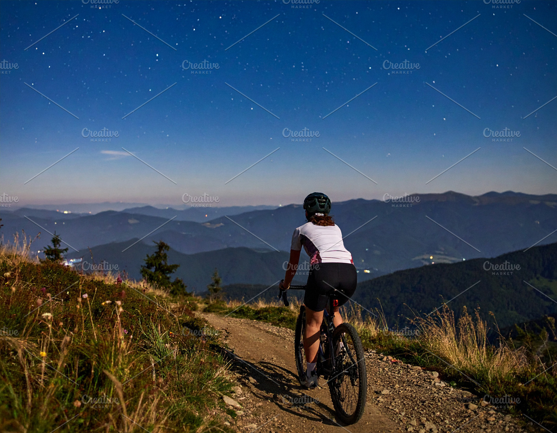 Young cyclist riding on a mountain trail at starry night, a Sports & Recreation Photo by DanFLCreativo