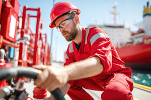 Worker operating equipment at port, an Industrial Photo by AlyaAnd