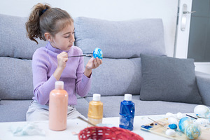 Little girl painting an Easter egg at home, a Food & Drink Photo by etorres69