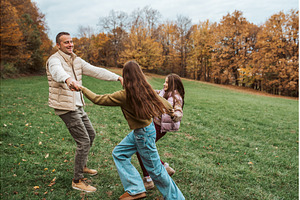 Father dancing with daughters, a Person Photo by HalfPoint