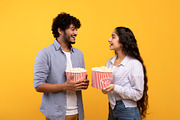 Leisure time together. Happy indian man and woman standing with popcorn, lookin, a Photo by Prostock-Studio (Thumbnail 5 of 6)