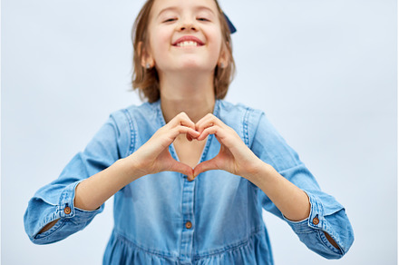Smiling little girl make heart sign, a Person Photo by IlliaBondarPhotography