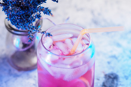 lavender drink with ice and lemon. stone background.