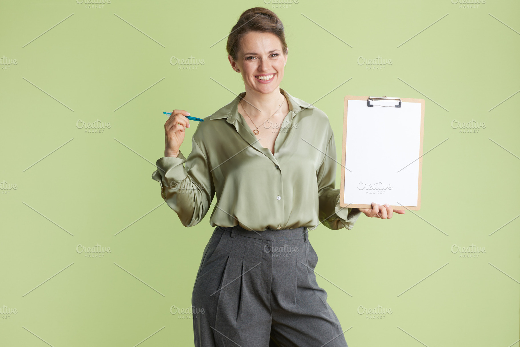 Smiling businesswoman with clipboard and pen, a Business Photo by Alliance Images