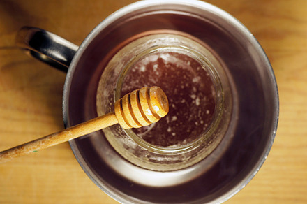 honey dipper close up with the organic produc on bacground unfoc