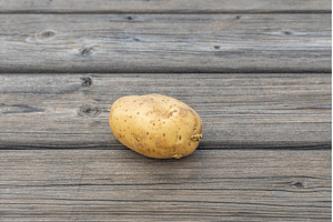 One potato on the gray wooden table, a Food & Drink Photo by Illustrations&photos