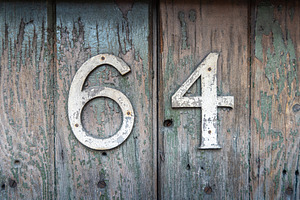 Weathered house number 64 on an old wooden surface, an Architecture Photo by GoodGoods