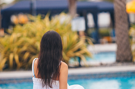 Young beautiful woman enjoying summer vacation in infinity luxury swimming pool, a Person Photo by travnikovstudio