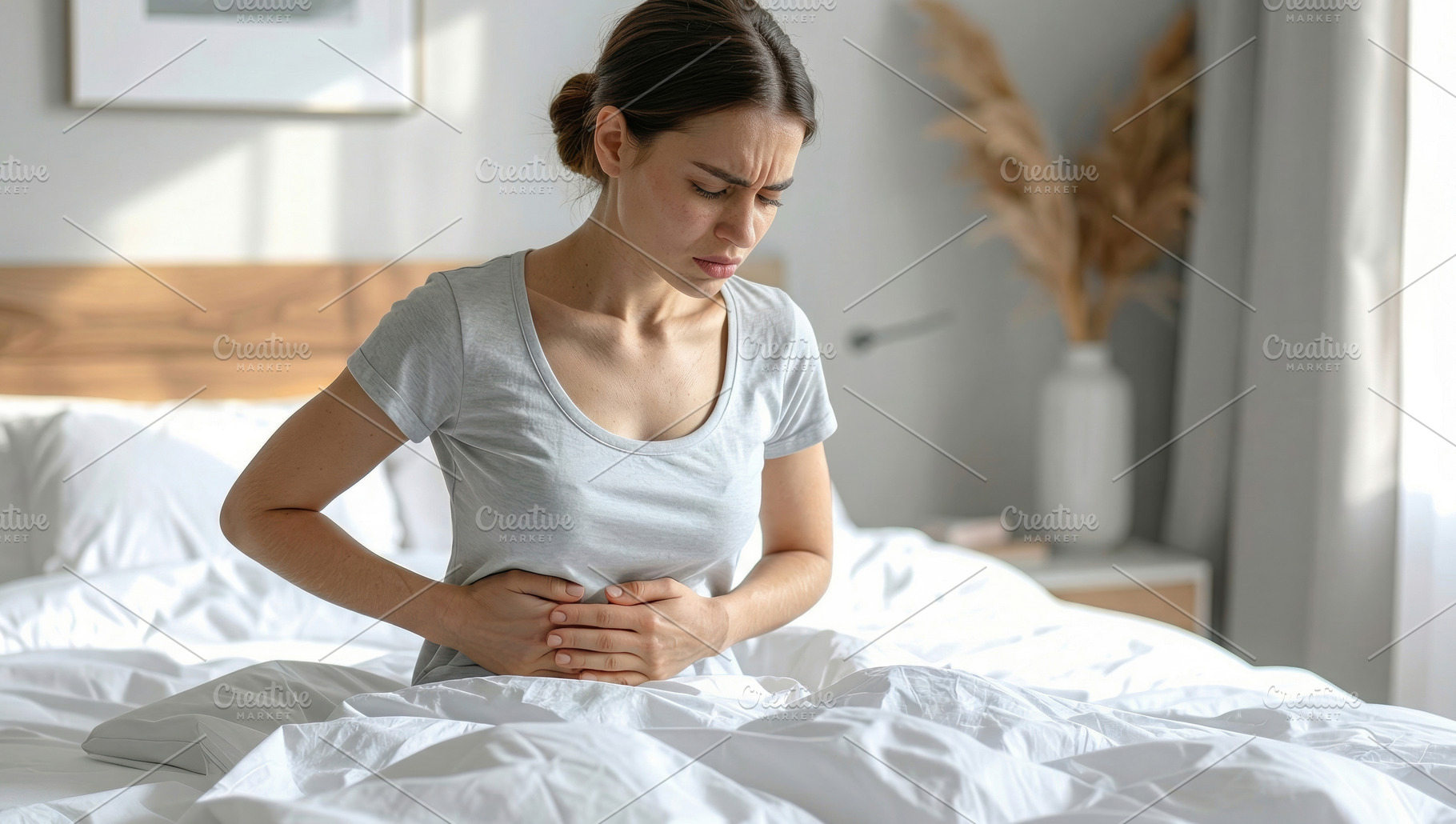 Woman Experiencing Stomach Pain Sitting in Bed, a Health & Medical Photo by Davizro's Market