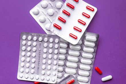 Tablets, pills and red white capsules packed and scattered. Top, a Background Photo by 5PH