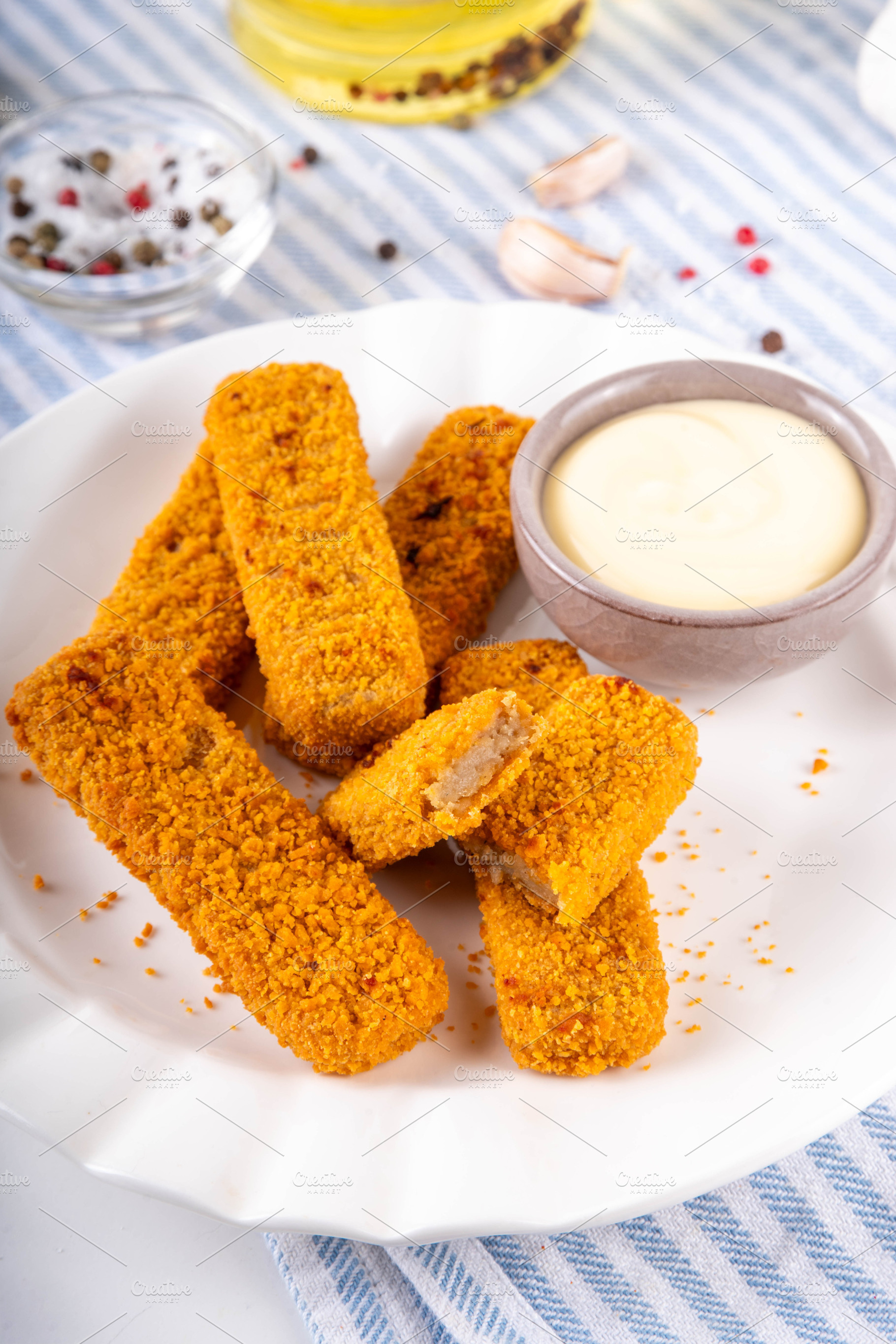 Fish sticks with white sauce on kitchen table, a Food & Drink Photo by Rimma