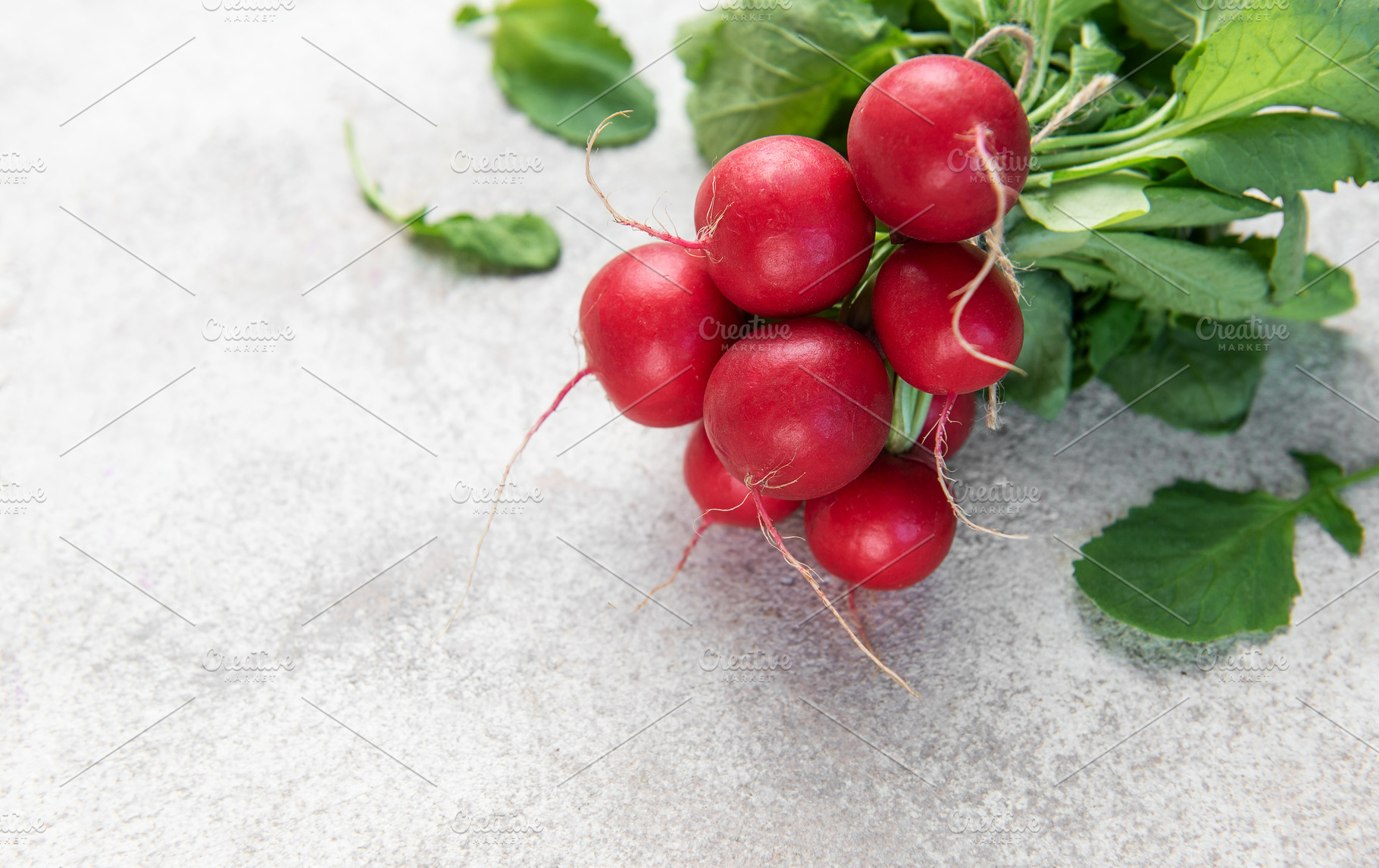 Fresh organic radishes with green leaves on light background, a Food & Drink Photo by Olena Rudo