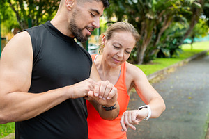 Fit couple checking smart watch during outdoor workout in tropical park, a Sports & Recreation Photo by etorres69