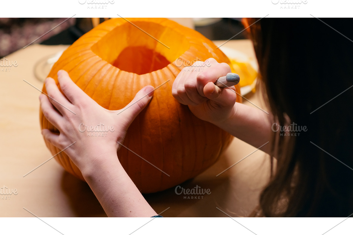 Woman carving Jack O Lantern pumpkin, a Graphic by sergeypeterman
