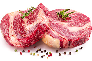 Raw beef steaks with herbs and spices ready for cooking on white, a Food & Drink Photo by Volff