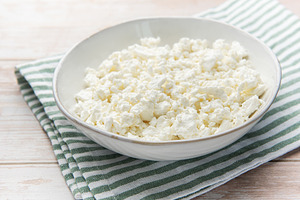 Cottage cheese in bowl on wooden table with green napkin, a Food & Drink Photo by Olena Rudo