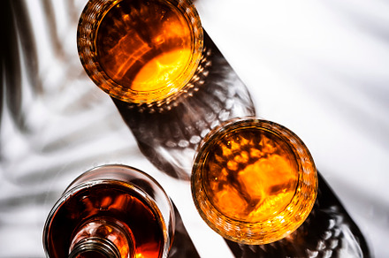 Whiskey in glasses and bottle, white background with hard light,, a Food & Drink Photo by 5PH