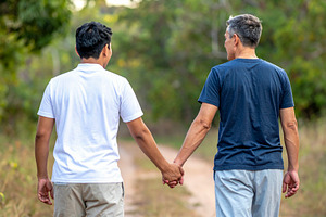 Back view of two men holding hands outdoors, a Technology Photo by DanFLCreativo