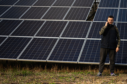 Man with mobile phone on the background of solar panels.  Eco en, a Technology Photo by AS photostudio
