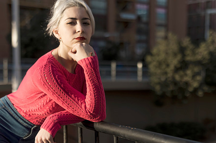 Slim young woman with blonde hair touching face and looking at camera while lea, a Person Photo by 2Design
