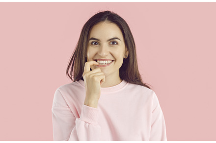 Excited young woman biting finger as, a Person Photo by StudioRomantic