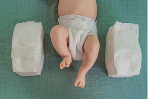 Baby lying between two stacks of, a Person Photo by Elizaveta Galitskaya