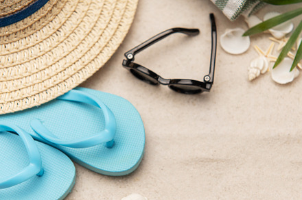 Beach accessories lying on sand creating summer vacation backgro