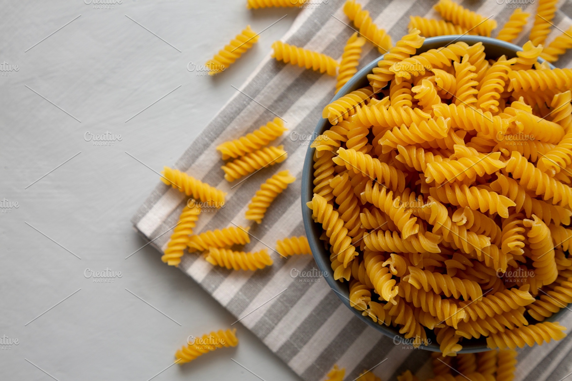 Dry Fusilli Pasta in a Bowl, top view. Flat lay, overhead, from, a Food & Drink Photo by LiudmylaChuhunova
