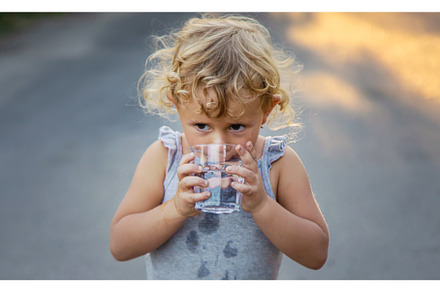 A child drinks water from a glass, a Person Photo by yanadjana
