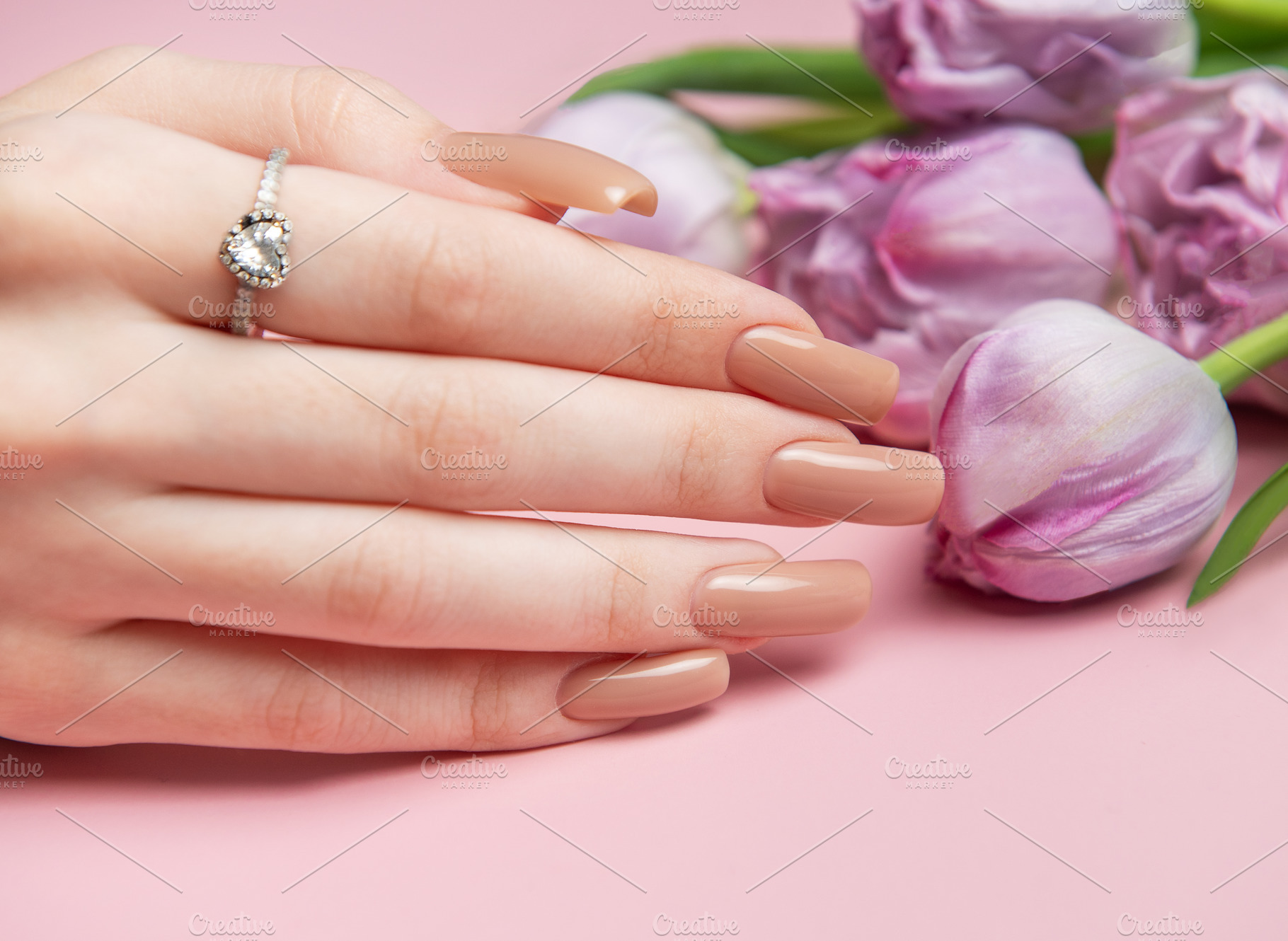 Woman showing nude manicure and engagement ring near tulips on p, a Beauty & Fashion Photo by Olena Rudo