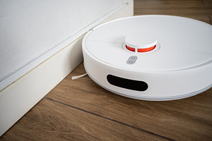 Robot vacuum cleaner cleaning wooden floor in modern living room, a Technology Photo by etorres69