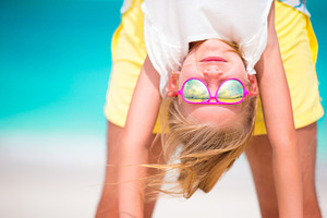 Little girl and her dad enjoy summer vacation at perfect beach