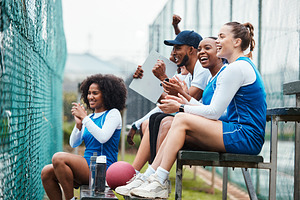 Court, netball and happy coach with women on stand watching game, match and practice on court. Coaching, teamwork and female athletes cheer for support, motivation and excited for sports competition, a Photo by Peopleimages.com