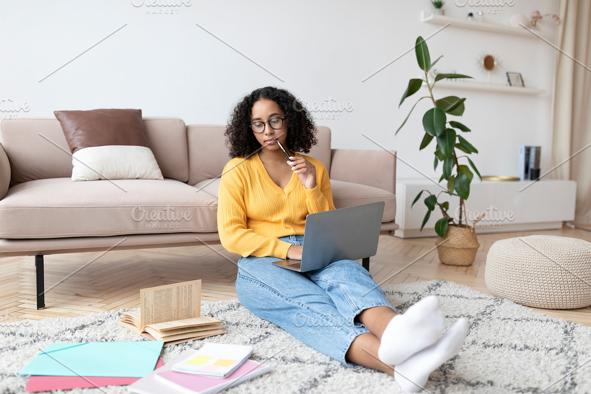 Young black wioman sitting on floor with study materials, having online class w, a Photo by Prostock-Studio (Photo 1 of 2)