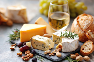 Delicious cheeses with rosemary crusty baguette served with a refreshing glass, a Food & Drink Photo by AlyaAnd