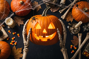 skeleton holding Halloween pumpkin