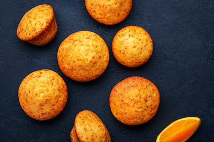 Sweet muffins with oranges and candied fruit on black table back, a Food & Drink Photo by 5PH