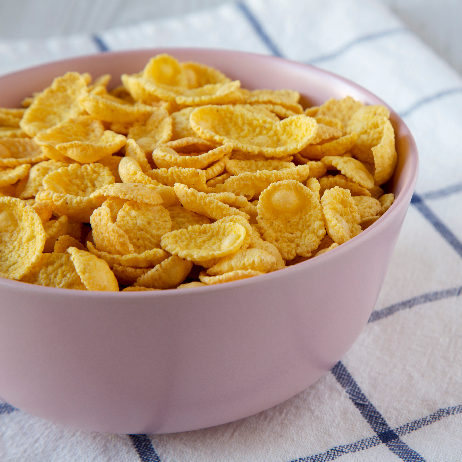 Corn flakes in a pink bowl containing cornflakes, corn, and flakes, a ...