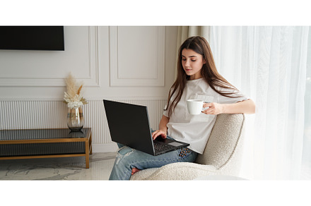 Young woman working at home by black