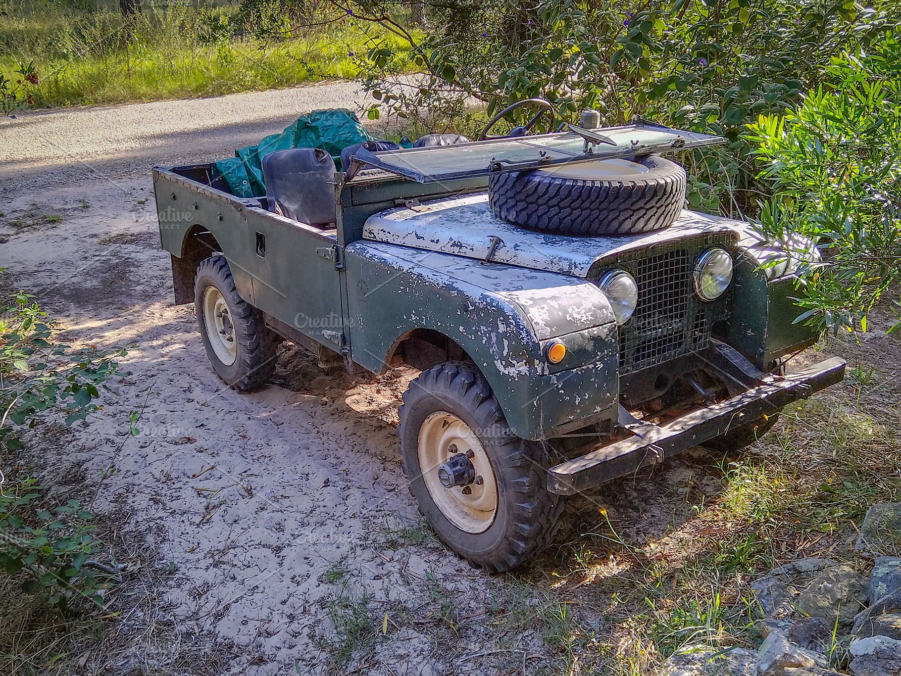 Vintage jeep parked in forest path, a Transportation Photo by DanFLCreativo