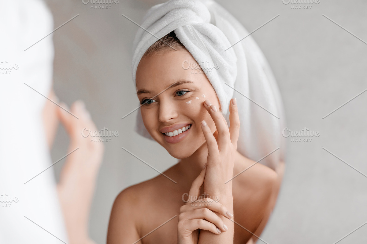 Portrait of young lady applying nourishing eye cream after shower, looking at m, a Photo by Prostock-Studio (Photo 2 of 2)
