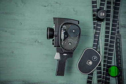 Old movie camera and film containing camera, film, and movie, an Arts & Entertainment Photo by SergeKa