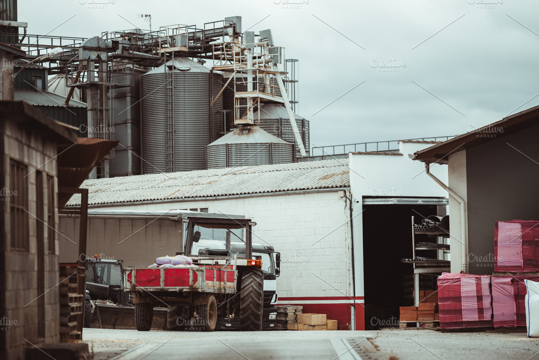 Tractor at grain silo facility, an Industrial Photo by SkyNext