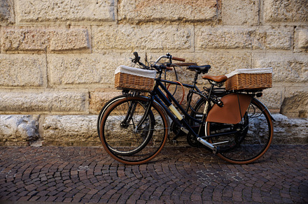 An old bicycles with wicker basket rests against a weathered wall in Mantua, It, a Transportation Photo by Bepslabor