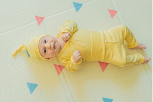 Adorable baby in a yellow hat lying, a Person Photo by Elizaveta Galitskaya