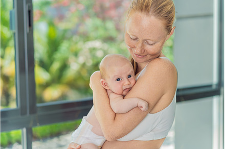 Mother gently hugging her baby at