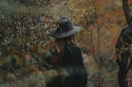 Girl in trees containing green, bush, and bushes