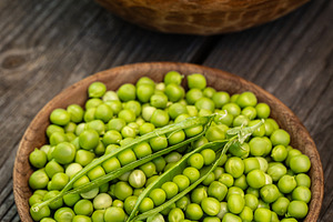Fresh green peas in wooden bowls, a Photo by Grafvision photography