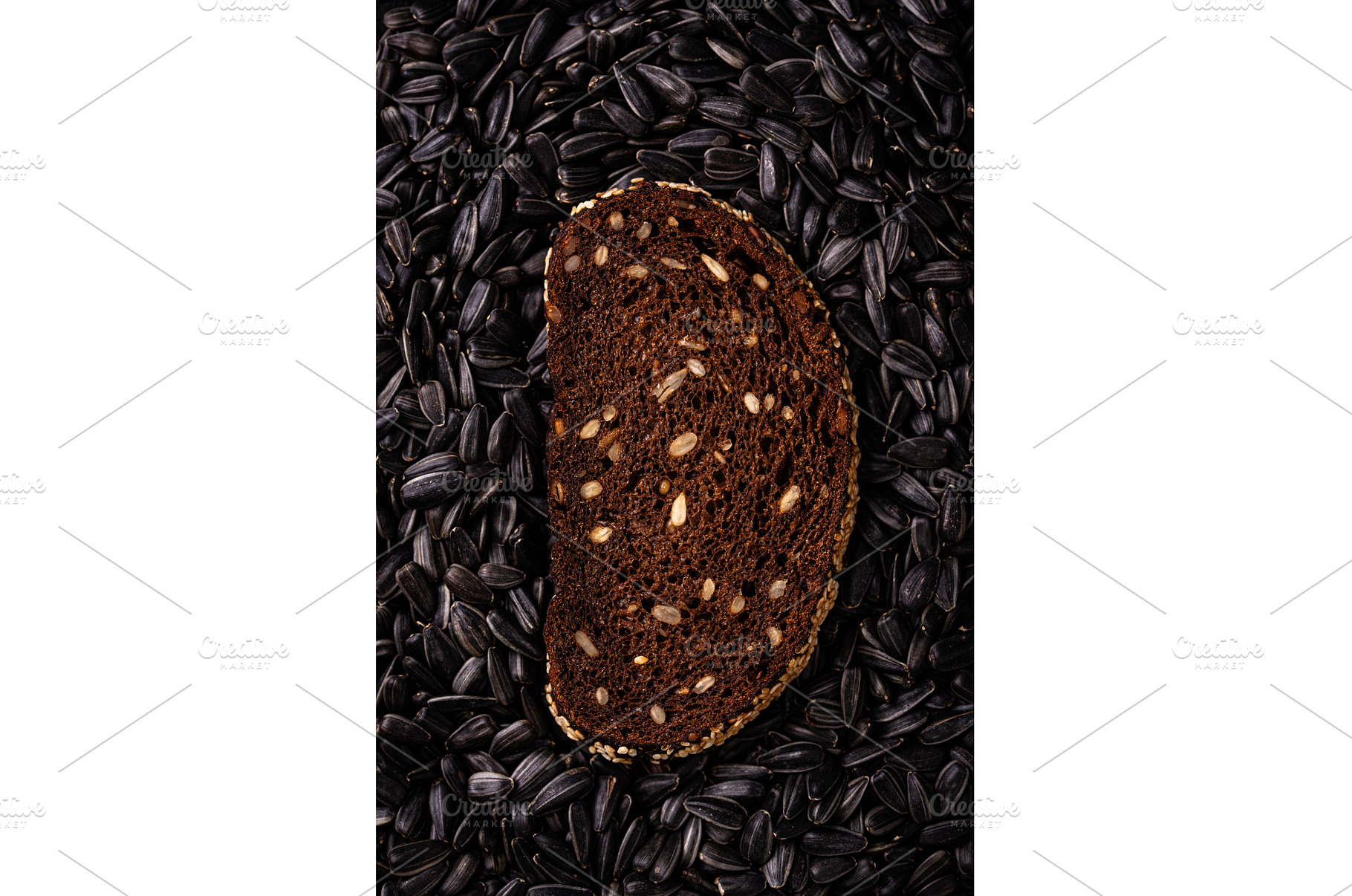 Slice of rye bread on black seed, a Food & Drink Photo by Yulia Furman